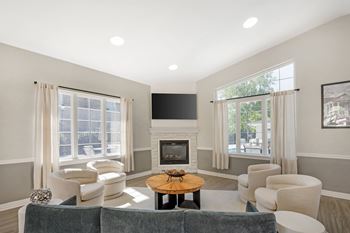 A living room with a grey couch, a coffee table, and a fireplace.